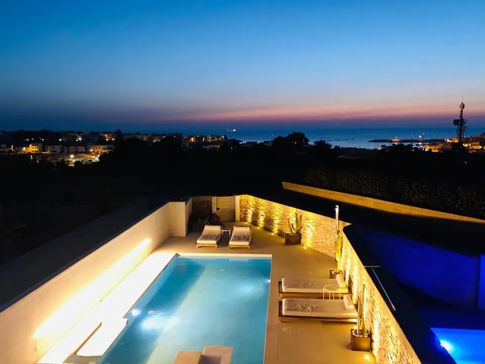 Pool at night overlooking the lights of Otranto