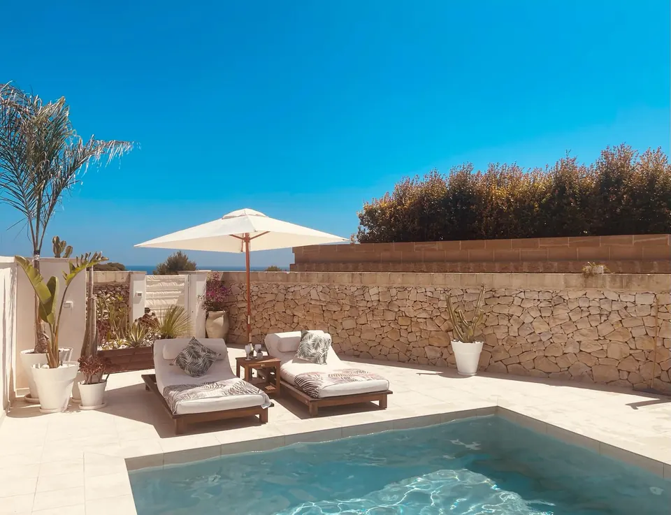Sun loungers under a parasol right by the pool
